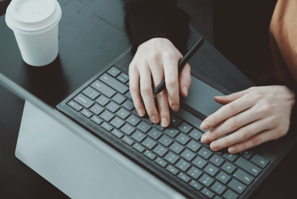 Person completing work on their laptop, while having a coffee.